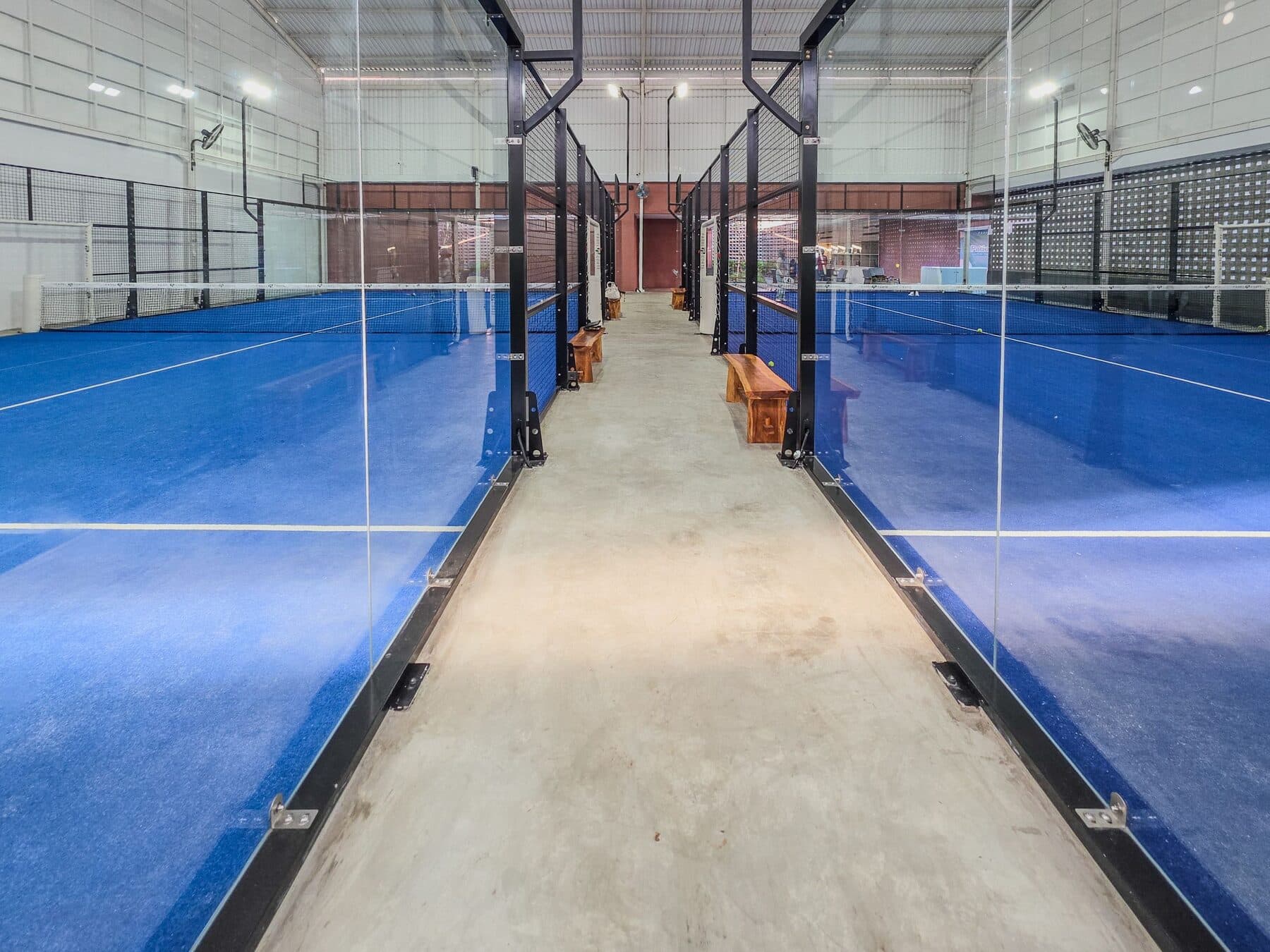 Una cancha de pádel cubierta, iluminada de noche.