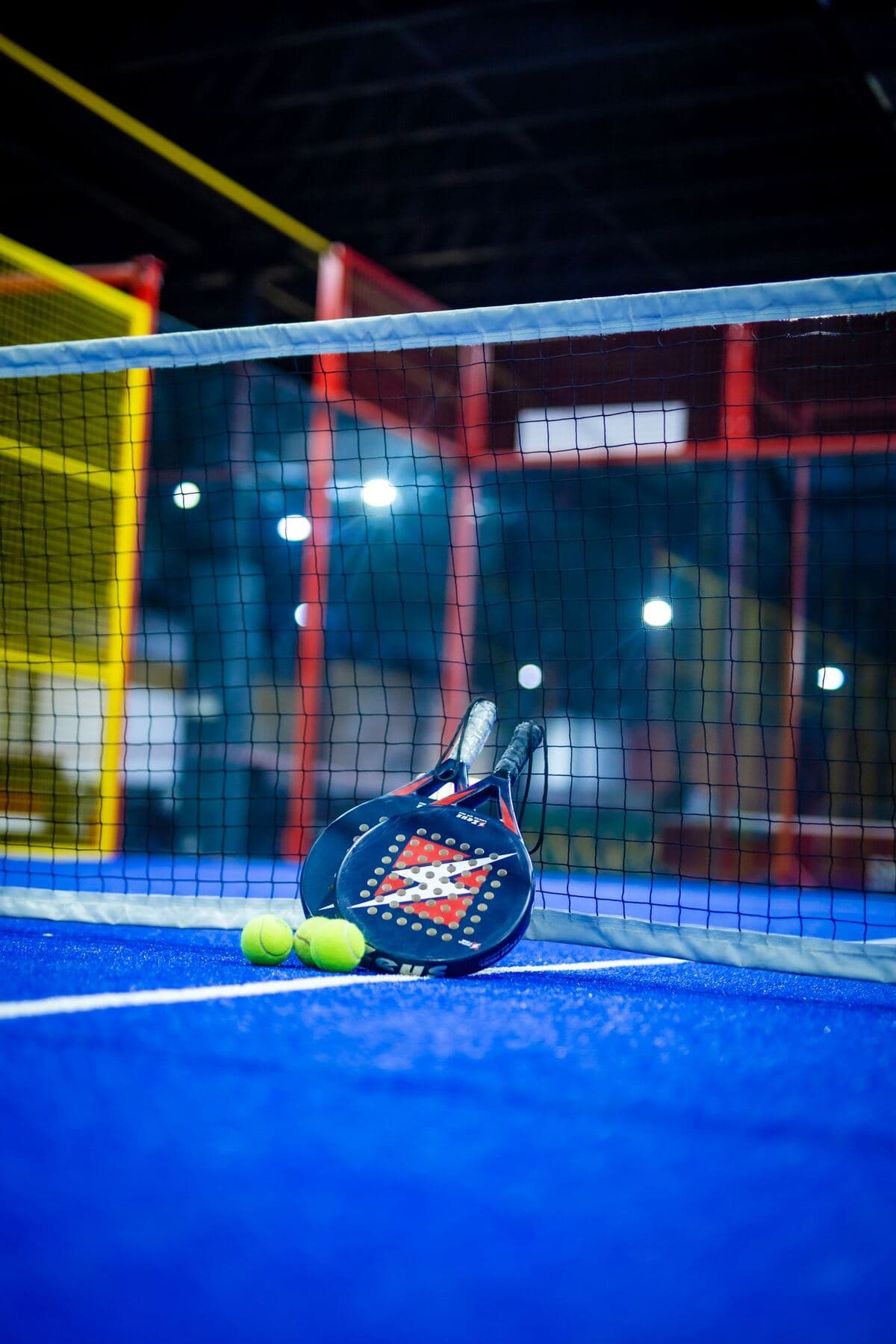 Una cancha de pádel cubierta, iluminada de noche.